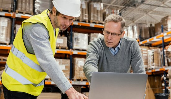 employé suivant les conseils d'un intervenant de formation sur un ordinateeur